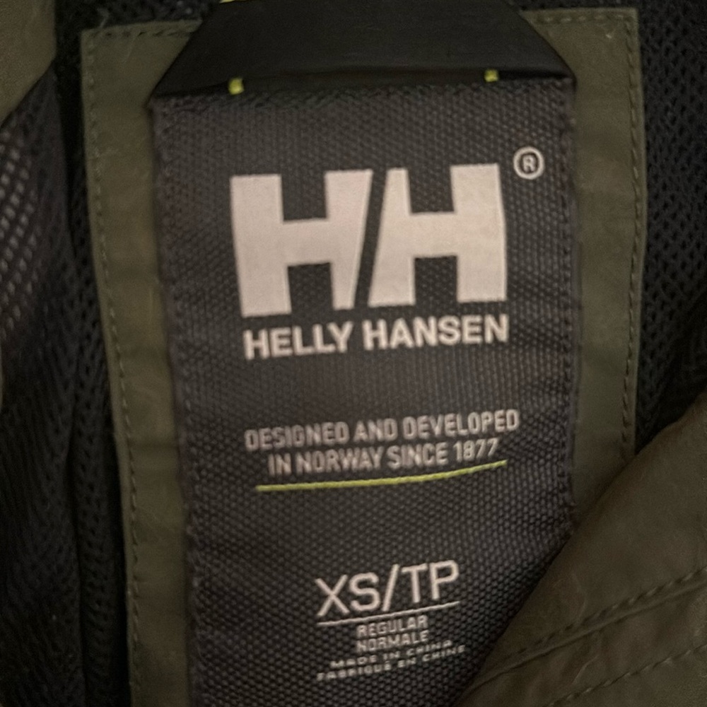 Waterproof, has hood, in green windbreaker in XS